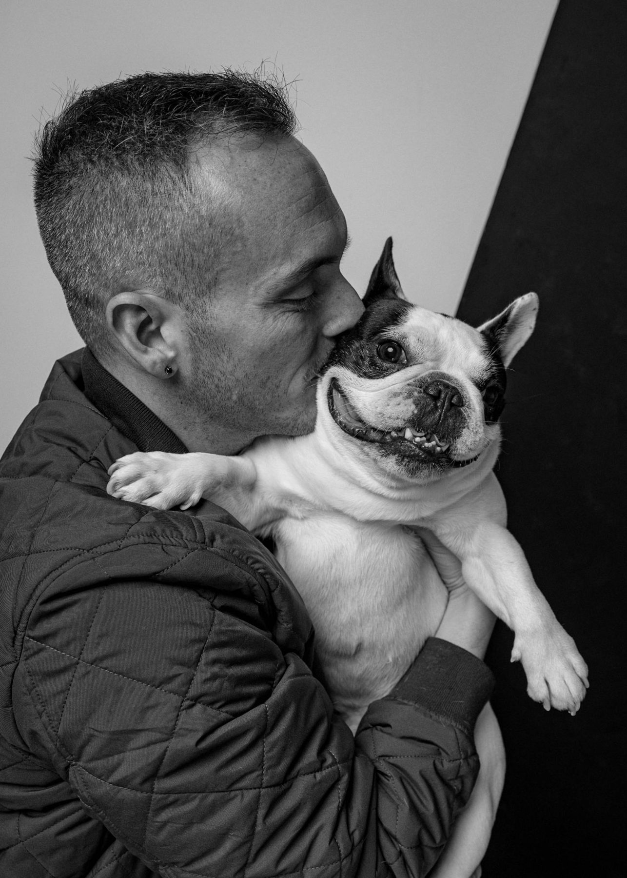 Tyler kissing his pied French bulldog