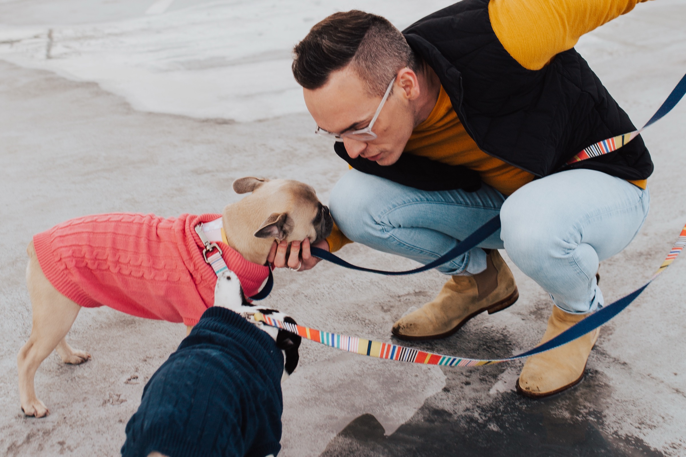 Tyler Gines crouching to greet his dog