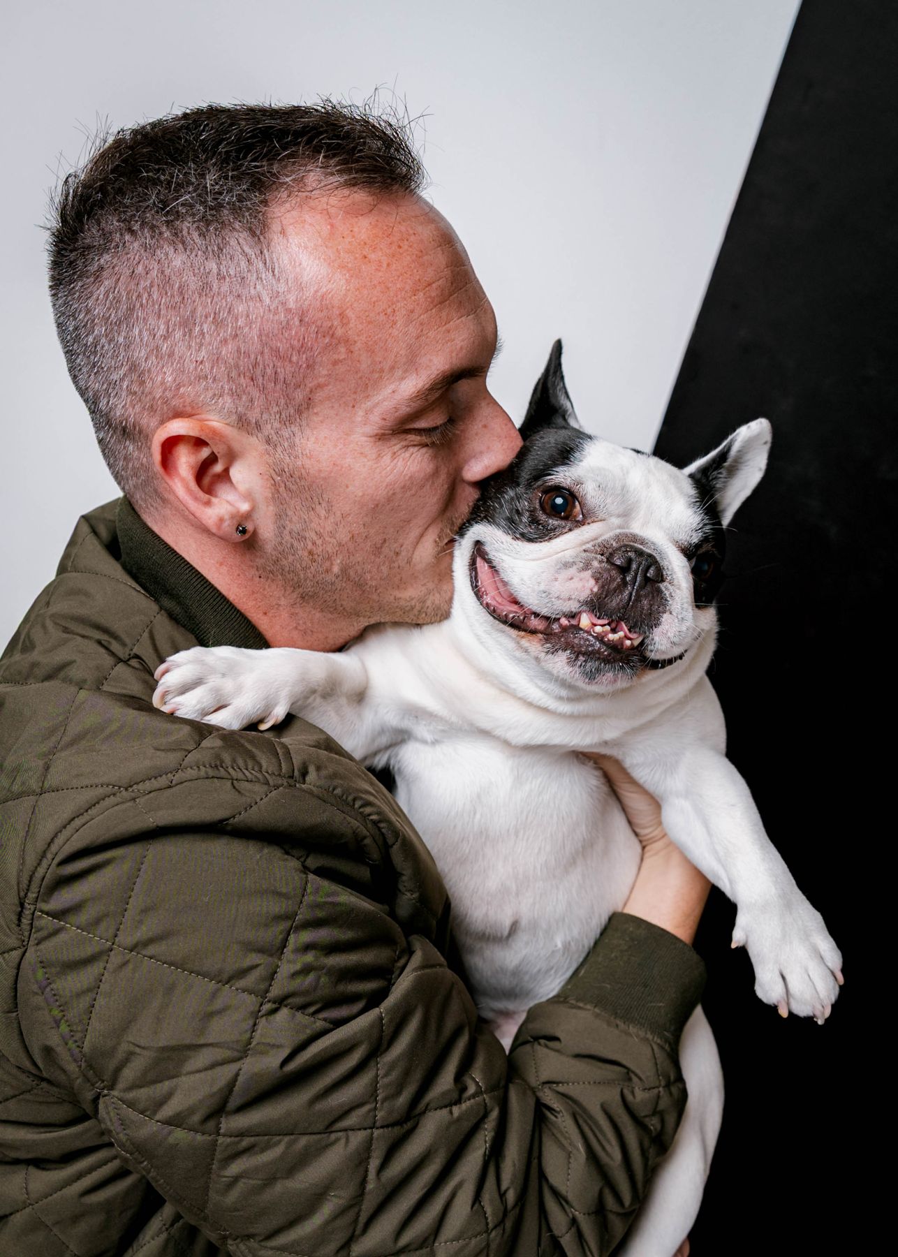 Tyler kissing his French bulldog